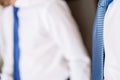 Detail of two businessmen with unfocused background, white shirts and blue ties and