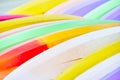 Detail of two rows of colorful stacked surfboards