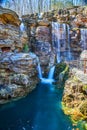 Detail of two waterfalls merging into river in cliffs by trail