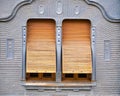 Detail of two windows with old wooden or metal shutters on a grey wall Royalty Free Stock Photo