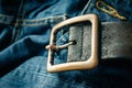 close up detail of an unbuckled leather belt on a faded pair of blue jeans Royalty Free Stock Photo