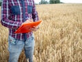 Detail of an unrecognizable farmer writing in a folder analyzing the harvest