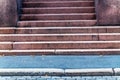 Detail of urban building entrance with aged and weathered stone stair facing the street and sidewalk in the city