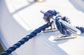 Nautical background, blue rope knotted on cleat of boat deck Royalty Free Stock Photo