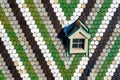 Detail view of colorful glazed tiles and window on the Stephansdom roof, Saint Stephens Cathedral in Vienna, Austria. Royalty Free Stock Photo