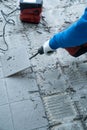 Construction worker using a handheld demolition hammer and wall breaker to chip away and remove old floor tiles during renovation Royalty Free Stock Photo