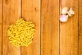 Detail view of garlic, macaroni and pasta on wooden background, top view, copy space for text, close up photo Royalty Free Stock Photo