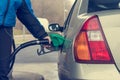 Detail view of hand holding fuel nozzle at petrol station. Royalty Free Stock Photo