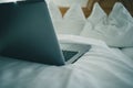 Detail view of a laptop keyboard sitting on a bed in hotel room. Vintage hotel room with laptop on the sheet. Concept of online Royalty Free Stock Photo