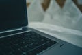 Detail view of a laptop keyboard sitting on a bed in hotel room. Vintage hotel room with laptop on the sheet. Concept of online Royalty Free Stock Photo