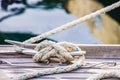 Nautical knot rope, tied on cleat at wooden deck on boat Royalty Free Stock Photo