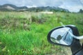 View of a rearview mirror of a car in a green grassy field Royalty Free Stock Photo