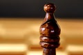 Detail view of the upper part of the chess piece of a black bishop, blurred background