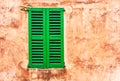 Green wood window shutter and rustic brown stucco wall background Royalty Free Stock Photo