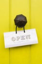 Detail of a vintage brass doorknob with open sign on a bright ye