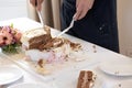 Detail of waiter cutting wedding cake during a marriage celebration party Royalty Free Stock Photo