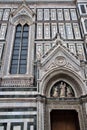 Detail of the wall of the cathedral Santa Maria del Fiore, a door with above the statue of the Madonna with Child in her arms and