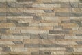 Detail of a wall of a long gray and brown brick. The facade of the building, built of natural stone. Background textur Royalty Free Stock Photo