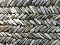 Detail of a wall made with aligned small clear grey and white stones.