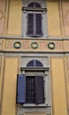Detail of the wall of Villa Stibbert overlooking the park. The image shows two windows and three colored crowns. Royalty Free Stock Photo