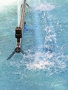 Detail of water jet spout in fountain with blue water and reflections. Blue water background with jet splash and mist. Pulsating Royalty Free Stock Photo