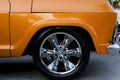 Detail of the wheel of an old car in a light orange color