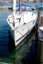 Detail of white boat in dock on Zurich lake with reflection on blue water surface on sunny day