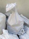 Detail of White debris raffia sack. White Canvas Membrane Plastic Bags With Construction Trash. Pile of plastic rubble sacks in