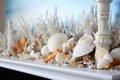 detail of a white fireplace mantel with seashell and lighthouse figurines