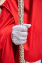 Detail of the white gloved hand of a Nazarene or penitent, holding a silver wand of command. selective focus with focus only on