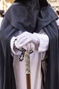 Detail of the white gloved hand of a Nazarene or penitent, holding a silver wand of command. selective focus with focus only on