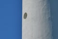 Detail of a white lighthouse. Dark blue background Royalty Free Stock Photo