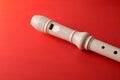 Detail of white plastic recorder mouthpiece on red gradient background
