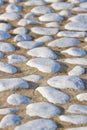 Detail of a white rounded pebble floor with white polished stone into a concrete subfloor Royalty Free Stock Photo