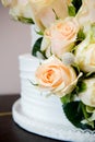 Detail of White Wedding Cake With Peach Roses and Lace.