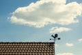 Detail of a wind vane with a shape of a on a roof