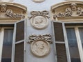 Windows with above decorated medallions in the historical center of Rome in Italy.