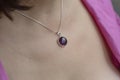 Woman neckline wearing amethyst mineral stone pendant on silver chain