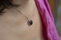 Woman neckline wearing obsidian mineral stone pendant on silver chain