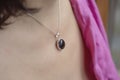 Woman neckline wearing obsidian mineral stone pendant on silver chain