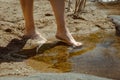 Detail of a woman's feet feeling the cool water of the river Royalty Free Stock Photo