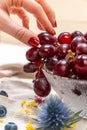 Detail of woman`s hand picking one red grape on a crystal bowl Royalty Free Stock Photo