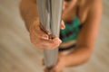 Detail of woman`s hands gripping a pole dance