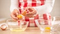 Detail of woman`s hands separating egg yolks from the whites into two glass bowls Royalty Free Stock Photo