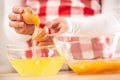 Detail of woman`s hands separating egg yolks from the whites into two glass bowls Royalty Free Stock Photo