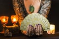 Detail of a woman`s hands showing a deck of tarot cards