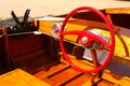 Detail of Wood Speed Boat with Bright Red Steering Wheel at Dock with gears and speedometer Royalty Free Stock Photo