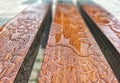 Wooden bench wet from the rain  reflections in the small puddles Royalty Free Stock Photo