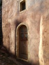 Detail of a wooden door and textured wall of a house at the old citadel town of Monemvassia, Greece, at dawn