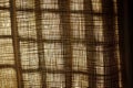detail of woven curtain texture with sunbeam silhouette, crisp play of light